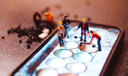 tiny model construction workers, working on a mobile phone screen