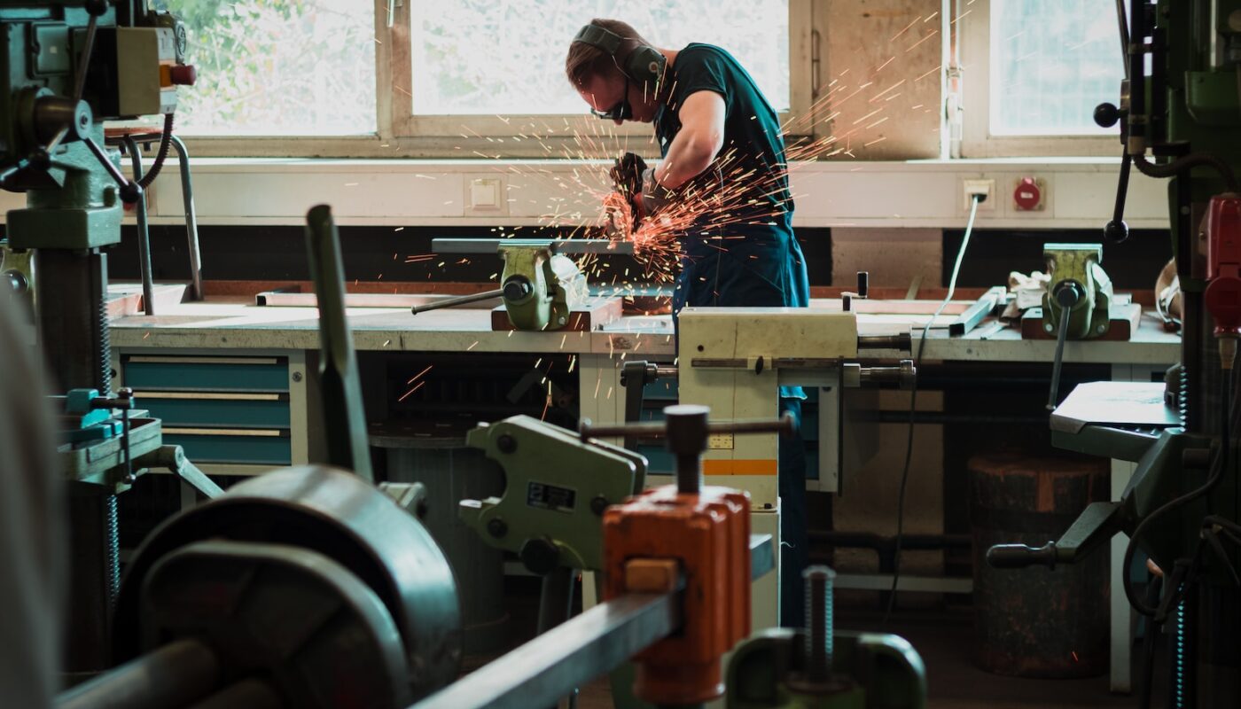 selective focus photography of man using angle grinder